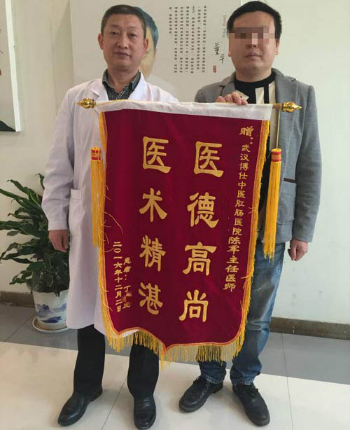 康复后的丁先生与陈军主任合影,并将第一面锦旗送到陈主任手中